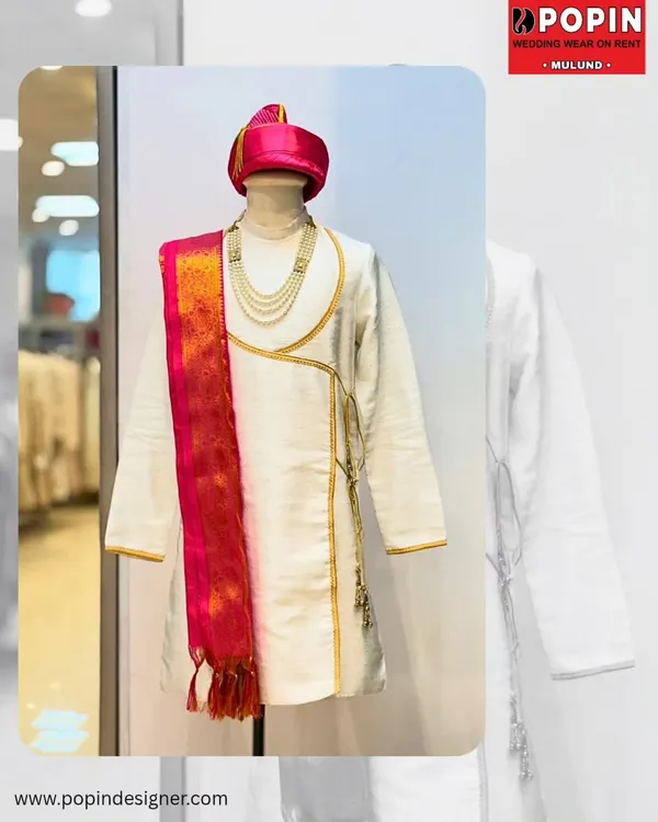 This is a classic Peshwai look, featuring a white angarkha-style kurta with a vibrant pink and gold dupatta. The pearl necklace completes the royal ensemble.