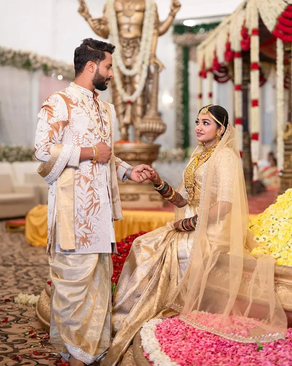 A beautiful moment from a traditional South Indian wedding ceremony. I designed this custom groom's outfit, featuring an off-white sherwani with intricate gold and white leaf embroidery, paired with a classic silk dhoti to honor our heritage.