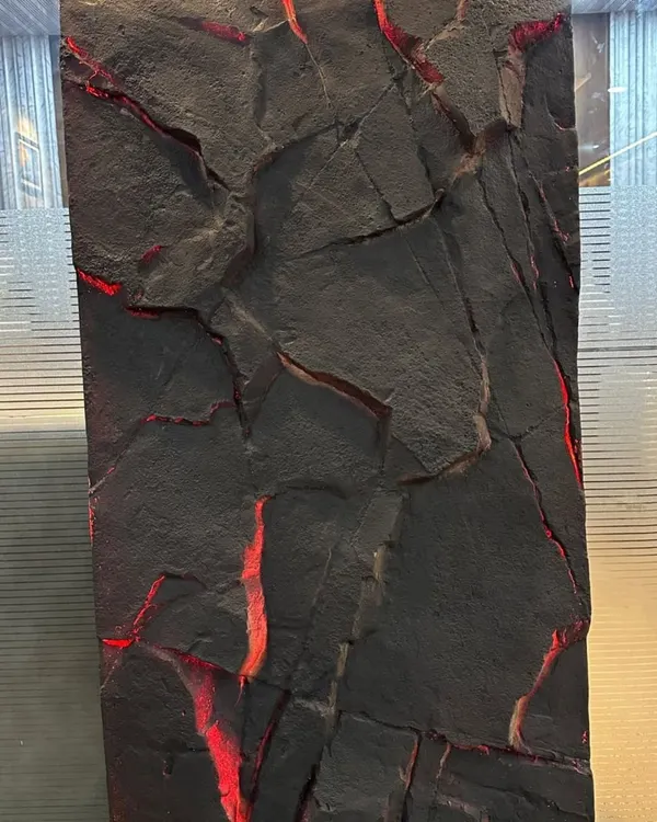 A close-up of our PU stone panel with integrated red backlighting. This creates a dramatic effect, highlighting the rugged texture of the stone.