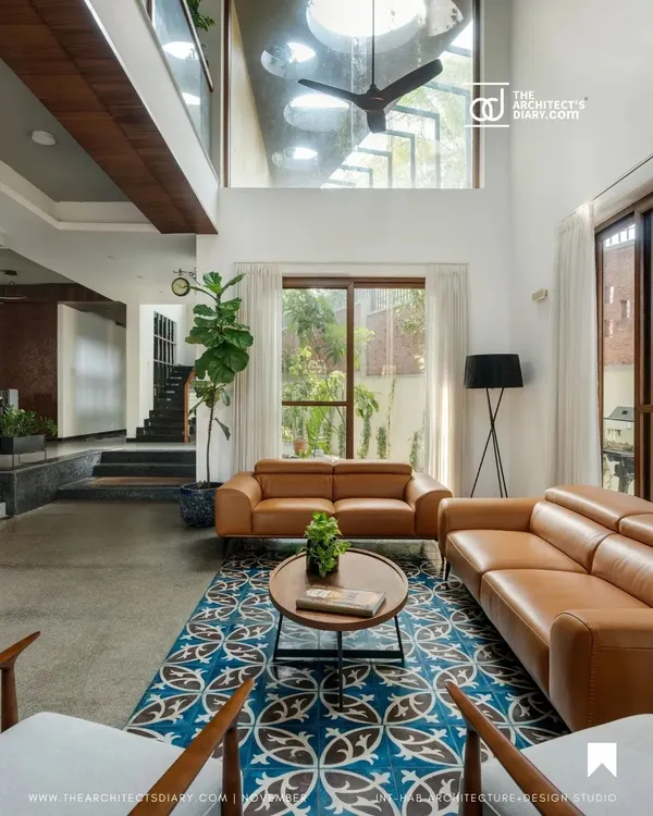 This double-height living room in our 'Jodi Mane' project captures my core belief in using vertical space and natural light. The large windows and skylights flood the area with sunlight, creating an airy, open atmosphere that connects the indoors with the surrounding greenery.