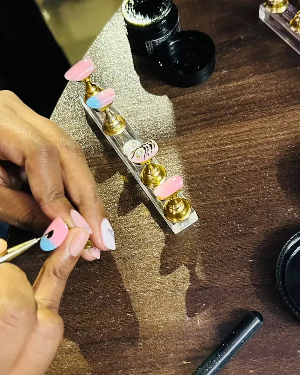 A glimpse into my workspace. Here I am, carefully hand-painting the details on a lotus-themed nail set. Every single nail gets my full attention to ensure it's perfect.