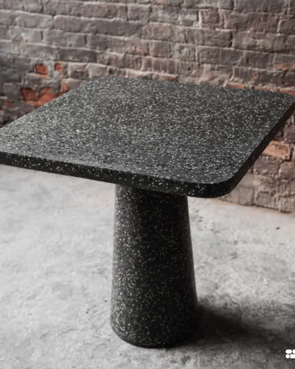 This beautiful black terrazzo cafe table, with its clean lines and monolithic form, was designed in collaboration with Loop Design Studio. It's a perfect example of how a simple shape can make a strong statement.