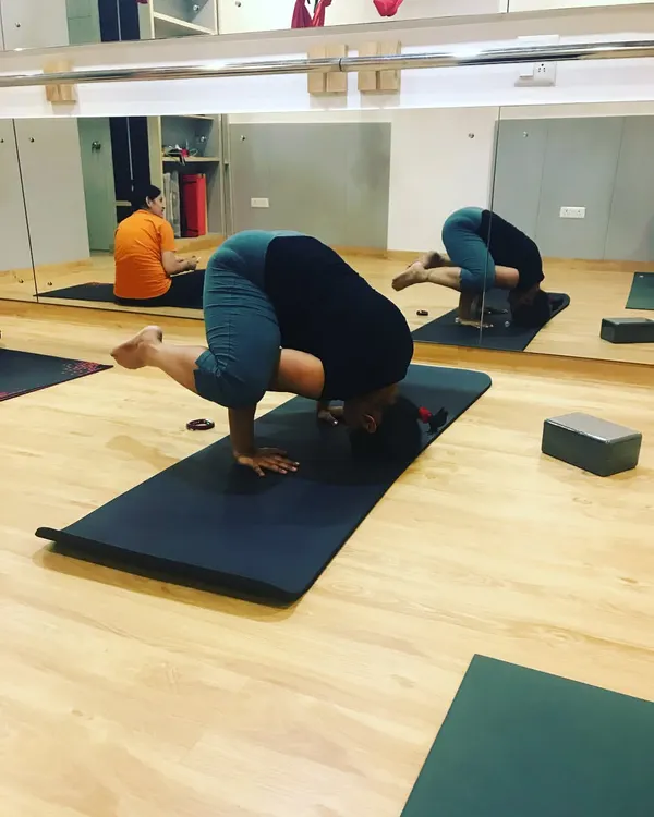 Witnessing a student's progress is one of the greatest joys of teaching. Here, a student is courageously working on her tripod headstand, building the core strength and confidence needed for inversions.