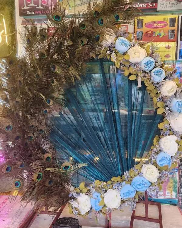 This is one of my signature Ganapati decoration frames, featuring a stunning arrangement of real peacock feathers and artificial flowers. It’s a unique and elegant backdrop that brings a divine touch to your festival celebrations at home.