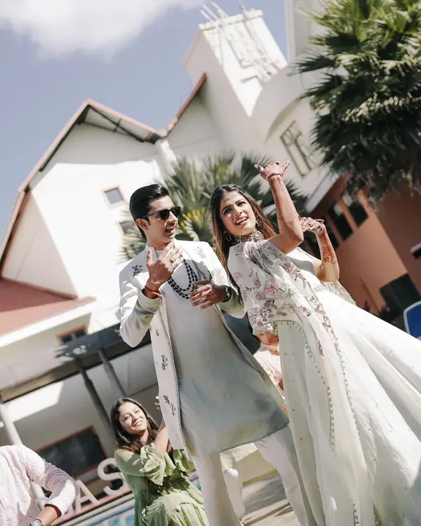 The dancing starts from the very first function. Here's the happy couple making their entry at the Haldi ceremony, surrounded by friends and family ready to dance.