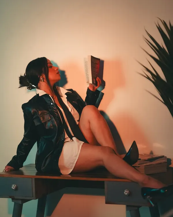 We continued the 'Boss Lady' concept with this shot, using a book as a prop to add to the character's story. The warm, focused light creates an intimate yet powerful atmosphere.
