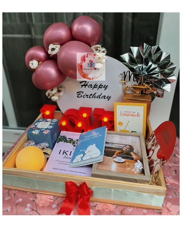 A stunning birthday tray curated for her, featuring a personalized LED initial, a mini balloon bouquet, framed photos, and a collection of her favorite treats and self-care items. This is how we make birthdays unforgettable.