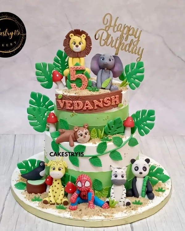 A fun two-tier jungle cake with a superhero twist. This chocolate cake features a variety of fondant jungle animals alongside a surprise appearance by Spiderman.