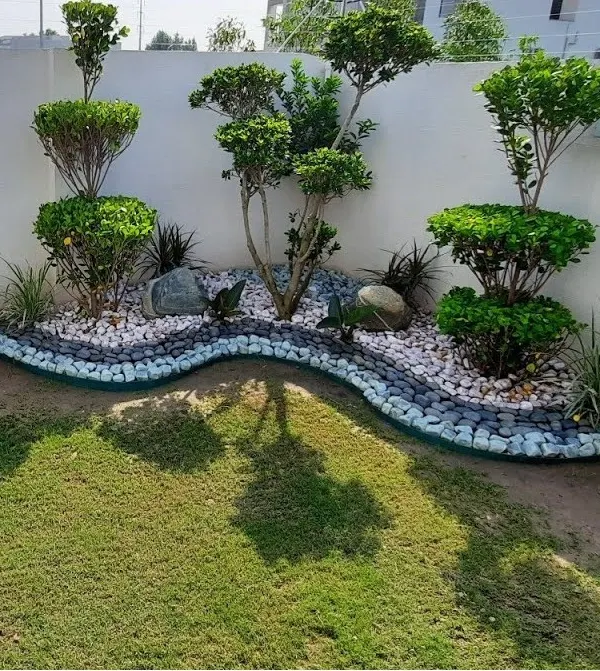 We specialize in creating striking landscape designs that become the centerpiece of your property. This project features carefully sculpted topiary trees, a lush lawn, and a dry riverbed effect using decorative pebbles for a modern, low-maintenance garden.