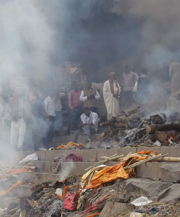 Smoke from cremation pyres fills the air at Manikarnika Ghat. This documentary photo captures the intensity of the final rites, a powerful part of the journey towards moksh.