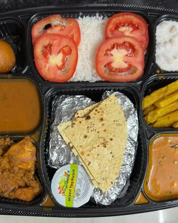 This is my special Karwa Chauth thali, packed with a variety of dishes to make your festive meal memorable. It includes two sabzis, dal, raita, rice, papad, salad, and a sweet, offering a complete and satisfying feast.