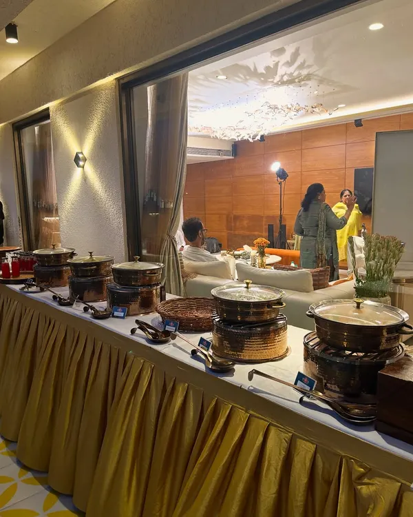 A wide shot of my stunning buffet setup at a client's home. The combination of golden table skirting and copper-finish dishes creates a luxurious and inviting look.