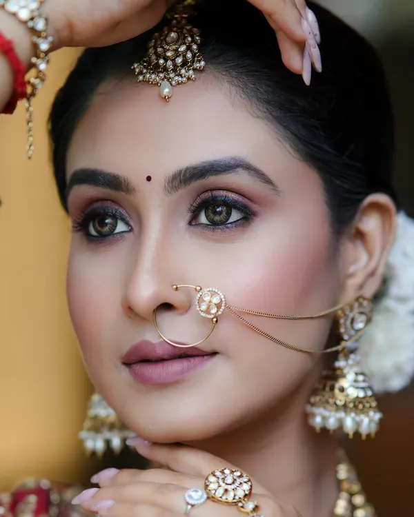 This is the radiant, flawless finish I strive for with every bride. This look features a soft, smoky eye and a matte lip, perfectly complementing the traditional red lehenga and intricate jewellery for a timeless bridal portrait.