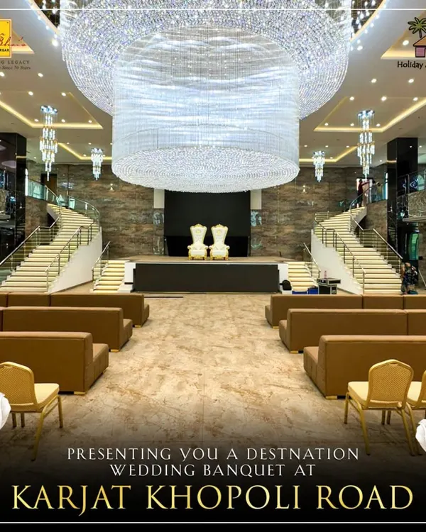 A full view of our majestic banquet hall in Karjat, designed for destination weddings. The central stage, flanked by grand staircases and crowned with a massive crystal chandelier, provides a breathtaking focal point for your special day.