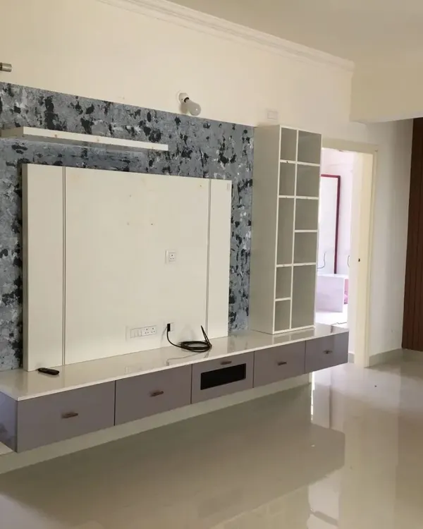 This modern TV unit is transformed into a statement piece with our signature "Drizzle" texture. We used a combination of grey, black, and white to create a sophisticated, marble-like effect that adds depth and character to this living room in Bengaluru.