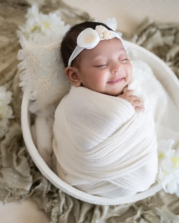 A heart-melting smile from a baby dreaming in a cozy white wrap. These are the precious, spontaneous moments I watch for during every session.