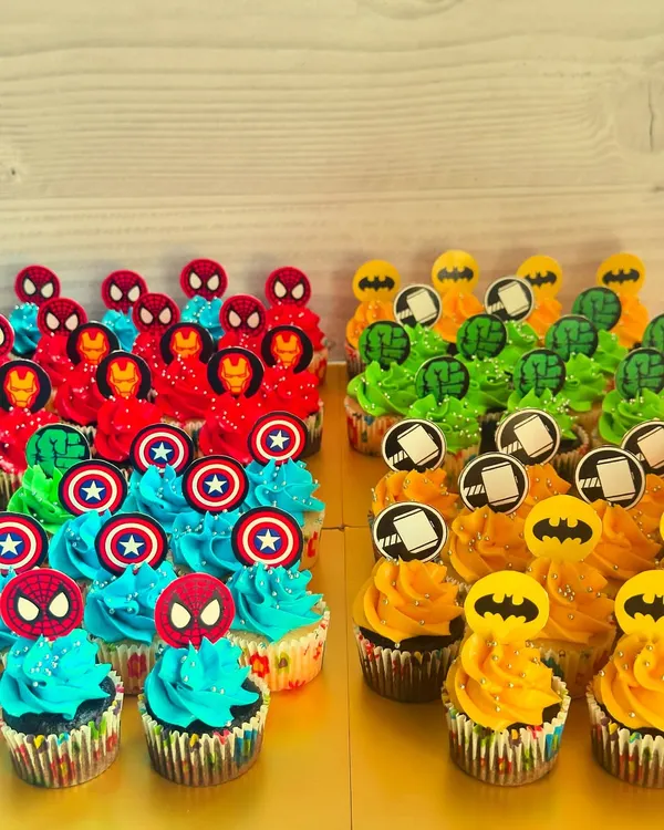 This colorful assortment of superhero mini cupcakes is a perfect example of my themed party sets. I can create designs for any character, like the Avengers, Batman, and Spiderman shown here, using vibrant buttercream and custom paper toppers to bring your child's favorite heroes to life.
