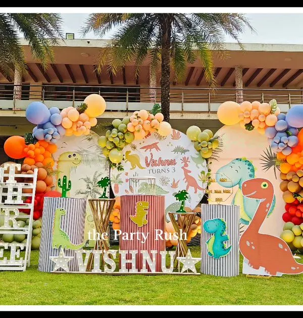 I transformed this outdoor space into a prehistoric playground for Vishnu's dinosaur-themed third birthday. This large-scale setup features custom dinosaur cutouts, themed plinths, and a vibrant balloon arch, creating an immersive experience for a truly roaring good time.
