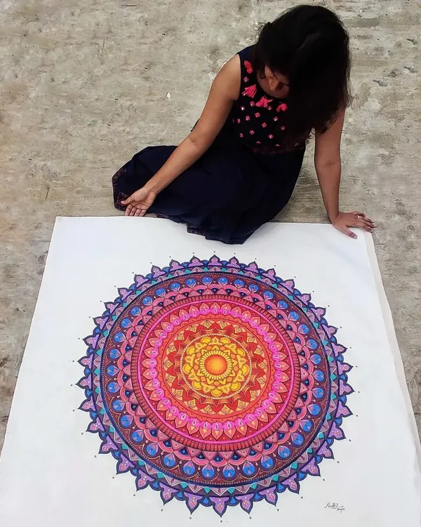 Here I am with a huge, custom-painted mandala on canvas. I love working on a large scale to create a truly immersive piece of art that becomes the centerpiece of any room.