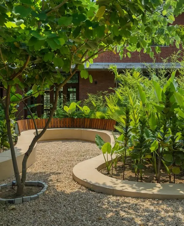 **Playfold, Ahmedabad:** We transformed a flat, underused courtyard into a dynamic landscape. A continuous, curving terrazzo bench snakes through the space, introducing movement and creating functional zones for seating, playing, and gathering.