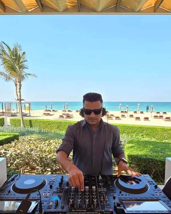 A daytime beach event requires a completely different energy. Here I am at a sundowner in Dubai, curating a relaxed yet groovy playlist as the sun sets over the ocean. It's all about matching the music to the mood.