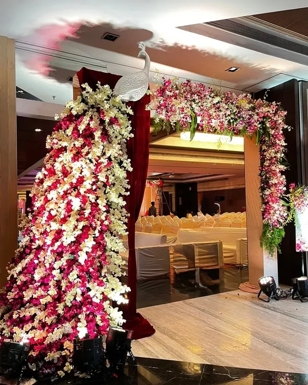 This entrance features a large peacock sculpture I crafted from pink and white flowers, connected to a matching floral arch. It creates a stunning welcome for wedding guests.