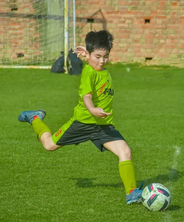 A young player from our academy strikes the ball with perfect form and power. We focus on teaching strong fundamentals from an early age.
