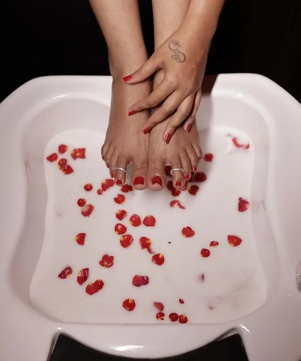 This is the kind of pampering I believe in. Here, a client is enjoying a luxurious pedicure foot soak with real rose petals. It's a simple treatment that softens the skin and soothes the senses, making you feel truly special.