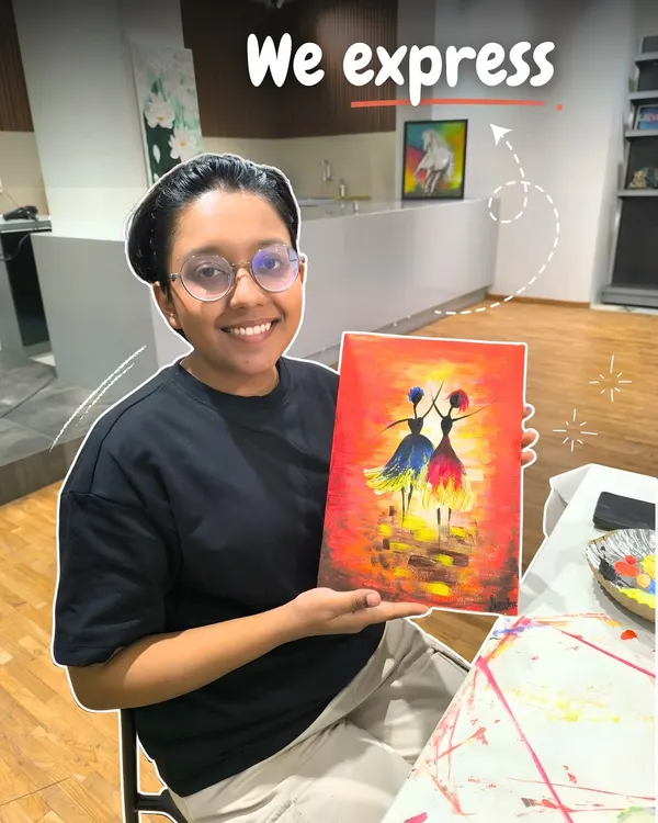 A smiling student proudly displays her colorful painting of two dancing figures, a beautiful piece she created during one of my expressive art classes.