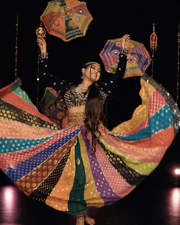The pure joy of Garba. A candid shot capturing the twirl of my multi-colored lehenga, a key element of Navratri performances. The vibrant colors and flowing fabric add to the visual spectacle of the dance.
