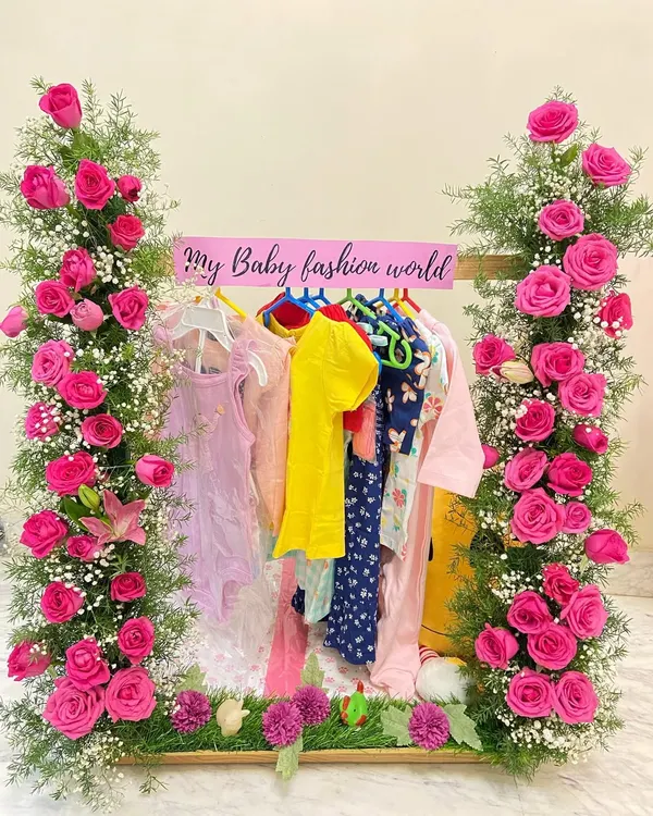 A beautiful welcome for a little one. This baby girl trousseau, designed as a floral closet hamper, combines practicality with stunning presentation, featuring tiny outfits and fresh flowers.