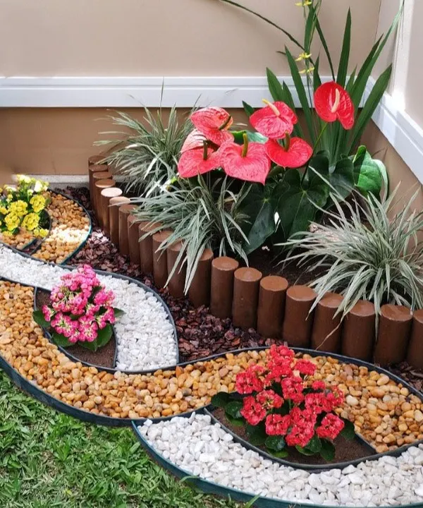 A beautiful example of mixed-media landscaping. We used wooden log borders, river pebbles, and colorful flowers to create this intricate and artistic garden corner.