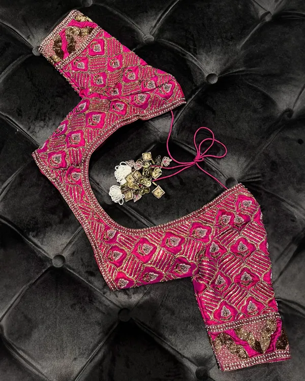 Personalized perfection. This meticulously embroidered pink blouse, with its intricate patterns and rich texture, is designed to elevate your signature style. It is a work of crafted couture.