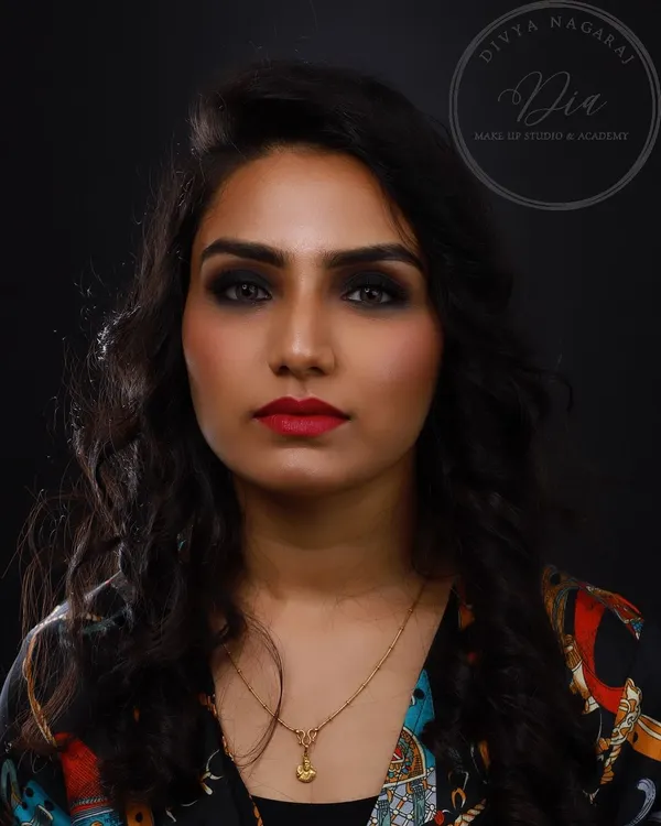 A powerful and classic look. This features a deep, black smoky eye, perfectly sculpted brows, and a classic red lip for a timelessly glamorous appeal.