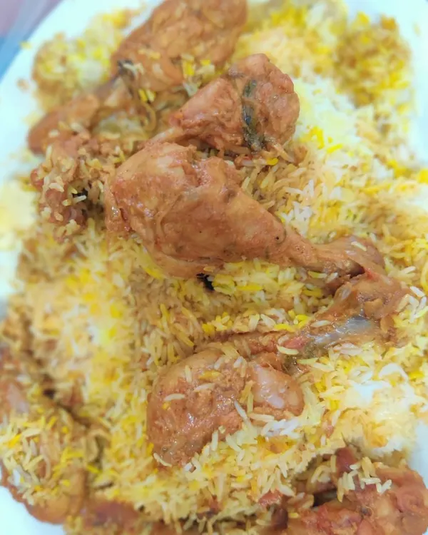 My Chicken Biryani, piled high and ready to serve. You can see the tender chicken drumsticks mixed in with the long-grain basmati rice, cooked with aromatic spices.
