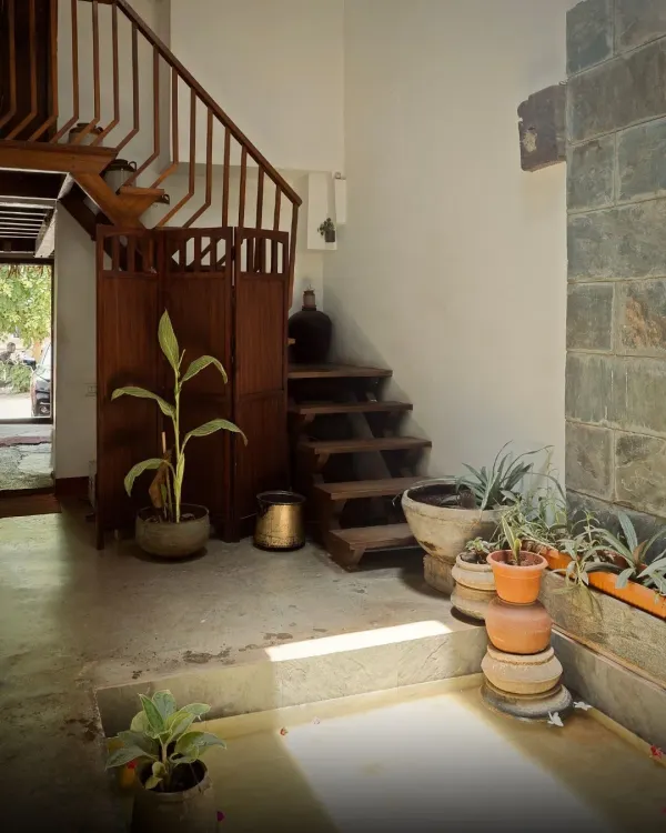 The entrance to the restored Mattur residence, a 200-year-old ancestral home. The design transforms a compact 10ft wide space into a grand narrative of light and tradition, using natural materials like stone and wood.