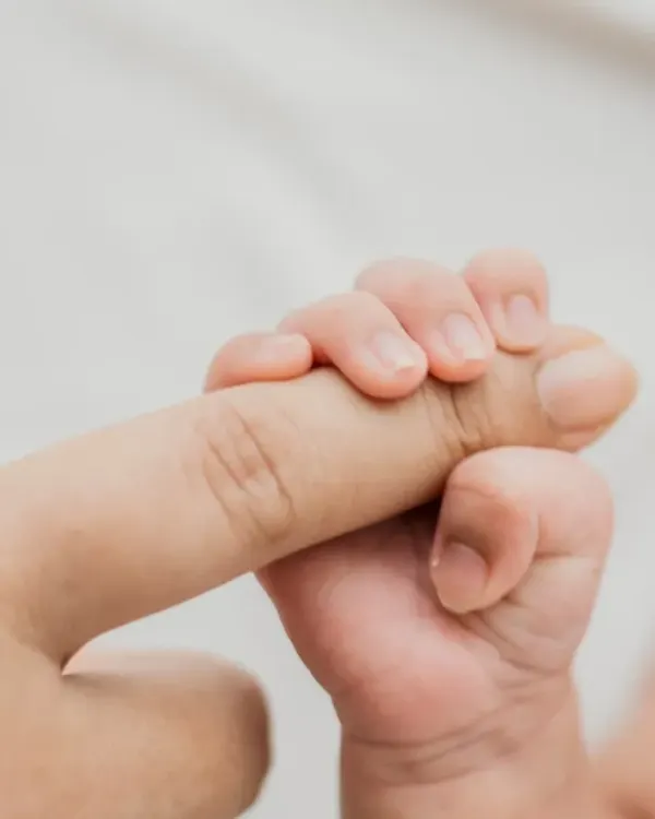 The strength in that tiny grip. A newborn holding onto a parent's finger is a classic, powerful image of connection and trust.
