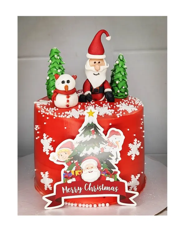 A festive Christmas tall cake with a mixed fruit flavor. This red cake is decorated with handmade fondant Santa and snowman toppers, snowflakes, and edible Christmas trees.