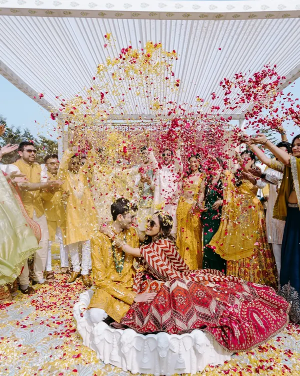A perfect explosion of color and joy. This shot of Tanika and Naman being showered with flower petals during their haldi ceremony in Jaipur captures the essence of a happy, chaotic celebration.
