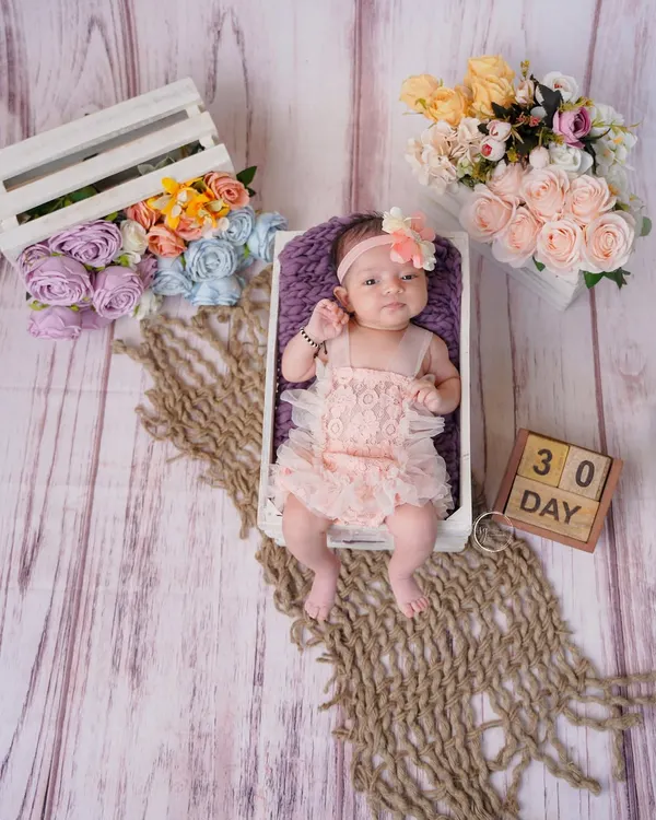 Celebrating 30 days of sweetness. This newborn portrait uses a miniature crate and floral accents to create a beautiful, rustic composition.
