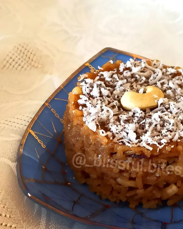 My Gur Wale Chawal (jaggery rice), a classic North Indian dessert that is both healthy and delicious. It's garnished with shredded coconut and a cashew for a final touch.