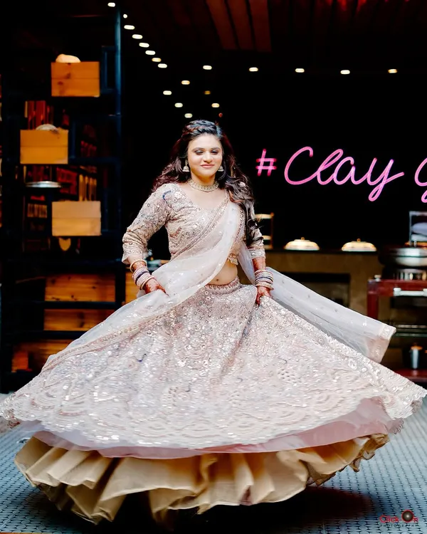 A beautiful full-length shot of the bride-to-be twirling in her shimmering lehenga at her engagement party. We capture the energy and glamour of your celebration.