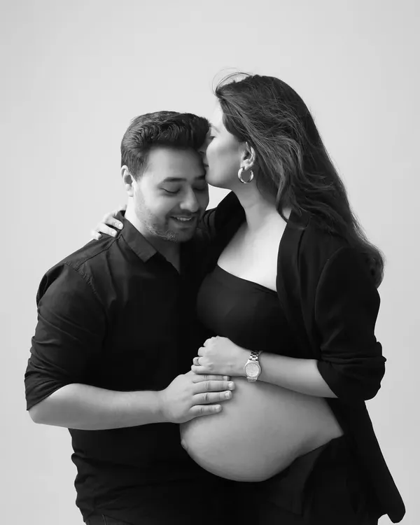 A tender moment captured in a modern style. This black and white portrait featuring a chic blazer look is both intimate and fashionable.