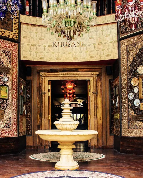 This is the grand entrance to Khubani. With a central fountain, towering Persian carpets, and a symphony of chandeliers, I welcome you into a world of unparalleled opulence.
