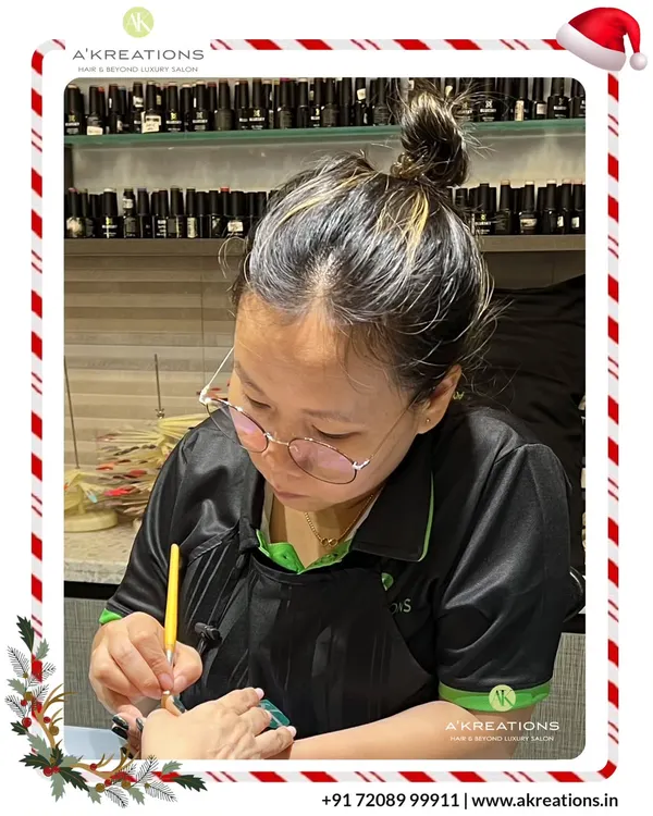 Our talented nail technician, Zingranphy, meticulously crafting a festive nail design with precision and artistry.