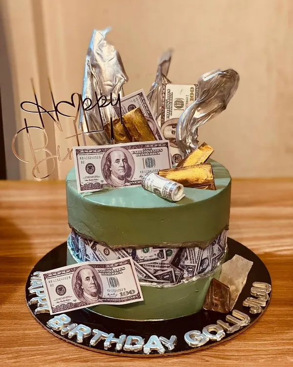 A stylish fault line cake with a money theme, featuring edible dollar bills.