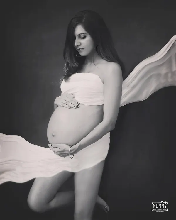 Simply divine. This black and white studio portrait uses a simple satin drape to create a classic, artistic photo that beautifully highlights the baby bump.
