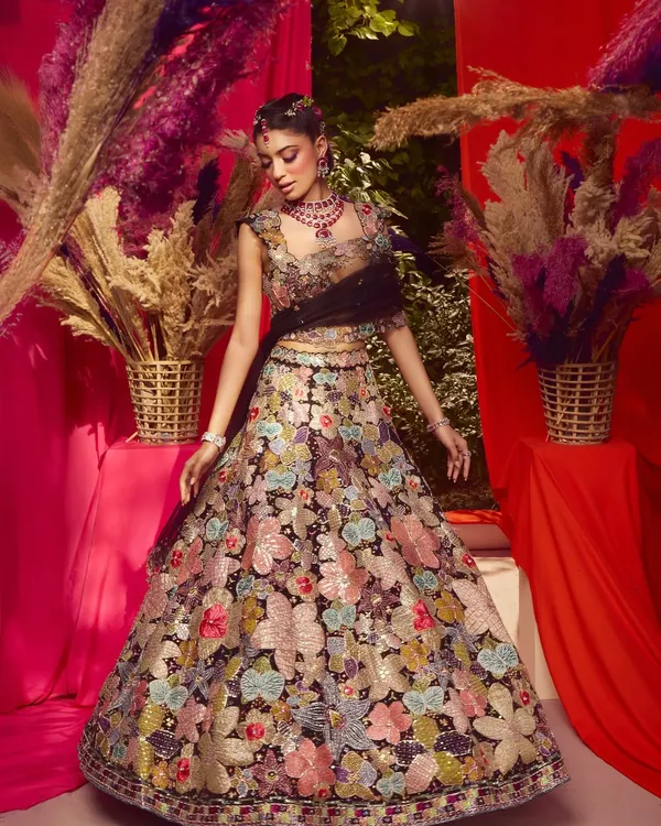 A celebration of bold beauty, intricate artistry and femininity. This look from a campaign shoot features a vibrant purple winged liner and floral details.