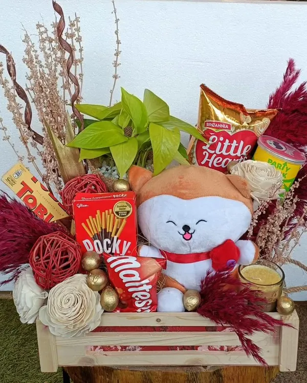 This cute and compact hamper is perfect for any occasion. It features a plush toy, snacks like Pocky and Maltesers, and is decorated with dried flowers for a rustic, charming look.