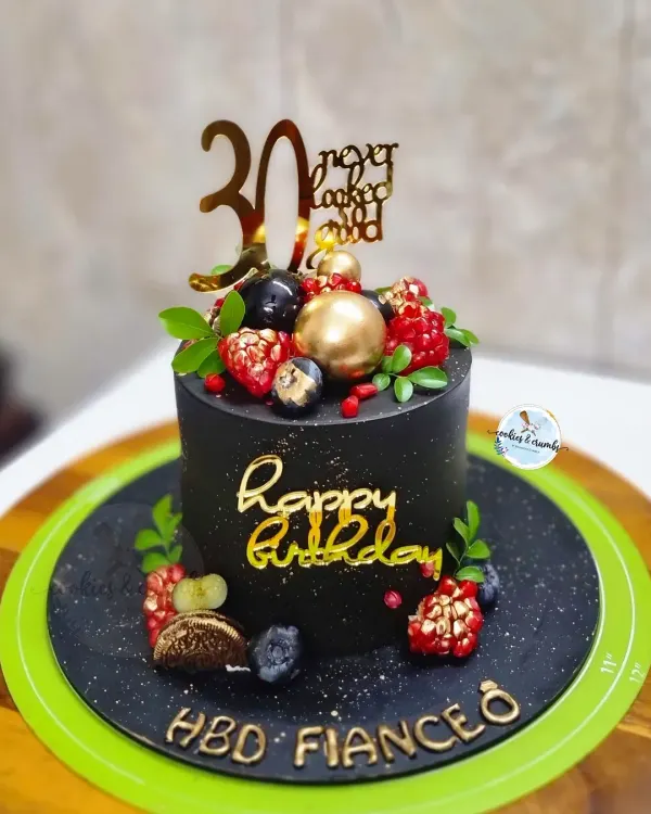 Milestone moments deserve a statement cake. This 30th birthday cake features a rich black buttercream, elegant gold script, and a topping of fresh berries for a touch of luxury.